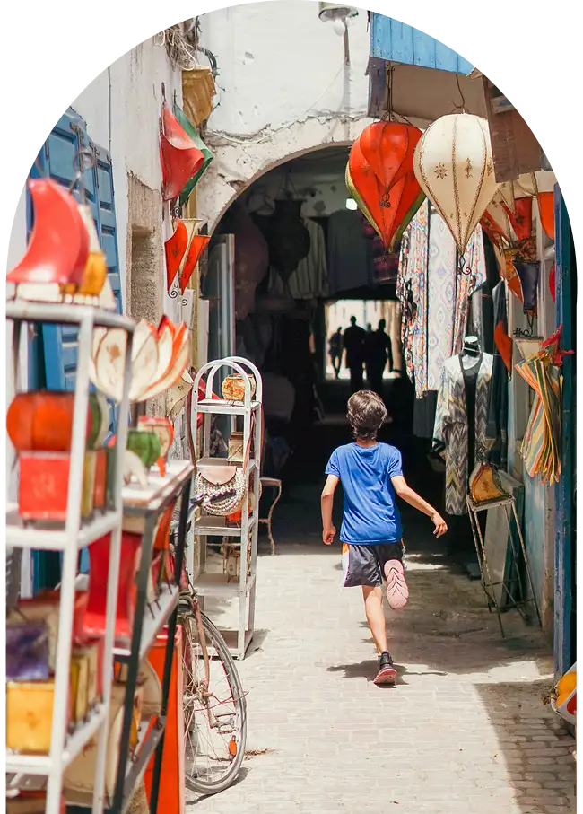 Enfant courant dans une ruelle commerçante de la médina d'Essaouira