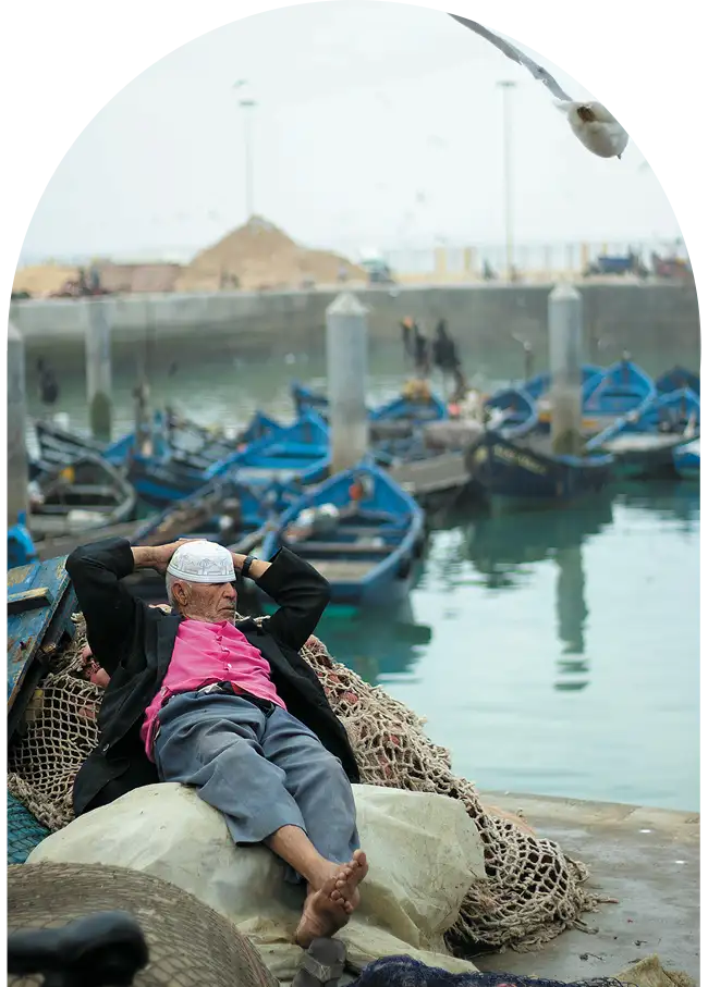 Homme marocain faisant la sieste au coeur du port d'Essaouira